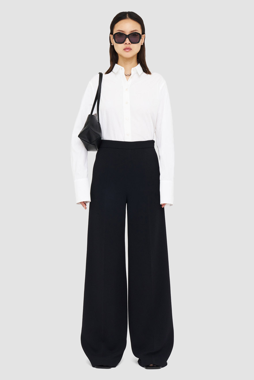Front view of female model wearing wide cut trousers