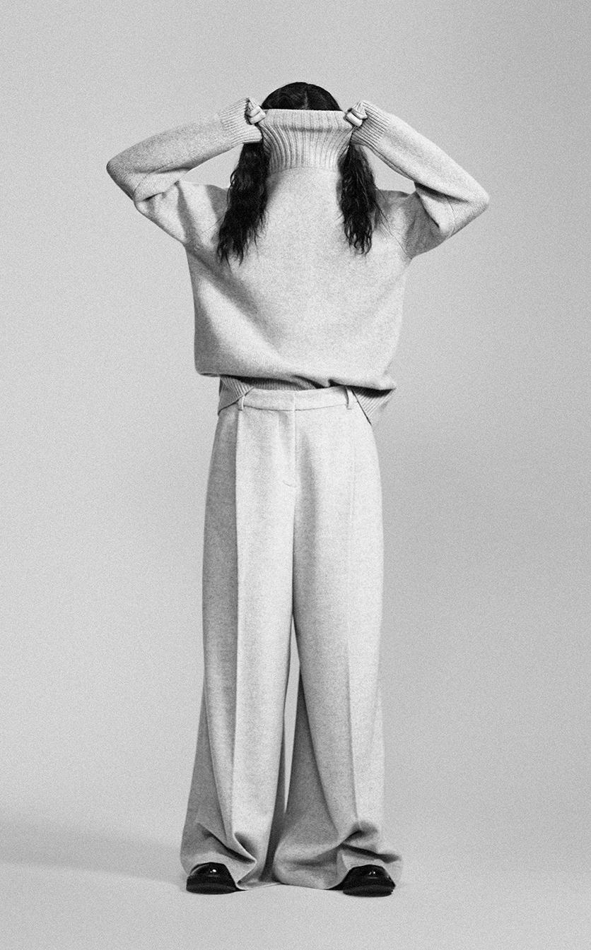 Greyscale image of a female model wearing wide cut trousers