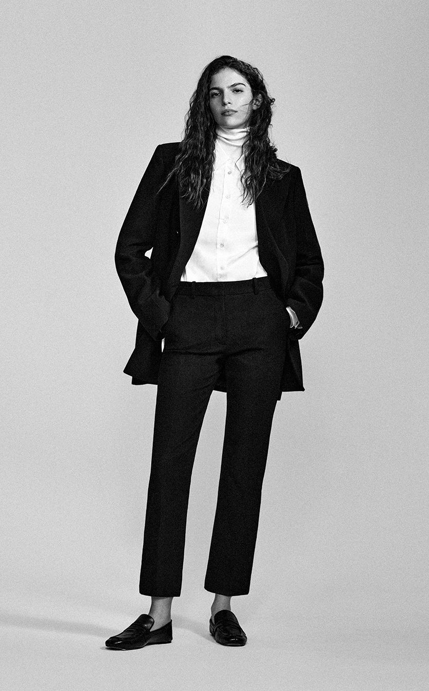 Greyscale image of a female model wearing straight cut trousers